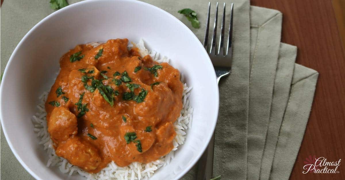 chicken tikka masala over rice in white bowl