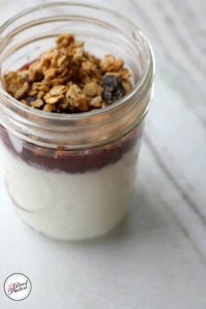 Instant Pot Yogurt in a single serve mason jar with strawberry compote and granola topping.