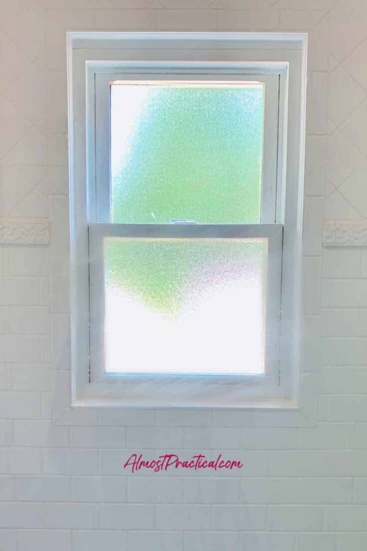 obscured glass window in the shower area of a bathroom surrounded by white tile