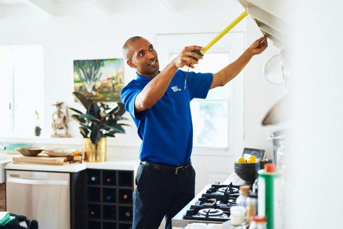 Best Buy In Home Advisor measuring a range hood in customers home.