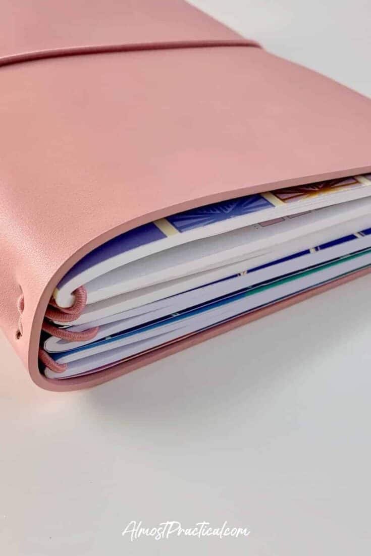 Erin Condren On the Go Folio in mauve filled with four Petite Planner notebooks.