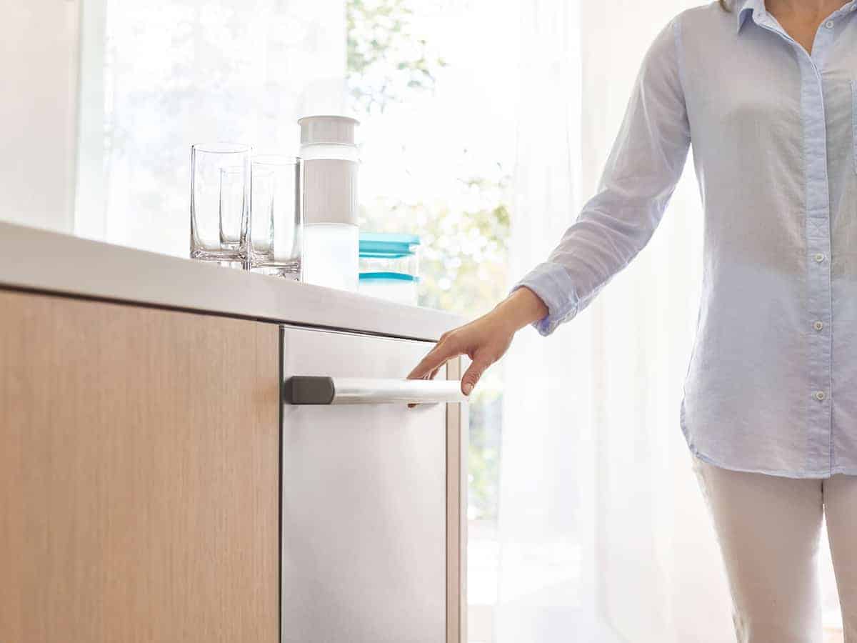 woman holding handle of Bosch 800 series dishwasher