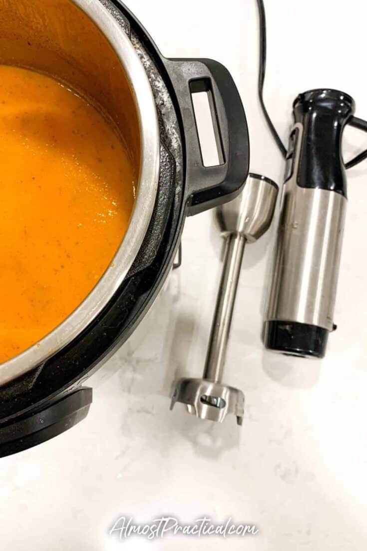 stick blender next to Instant Pot filled with tomato soup