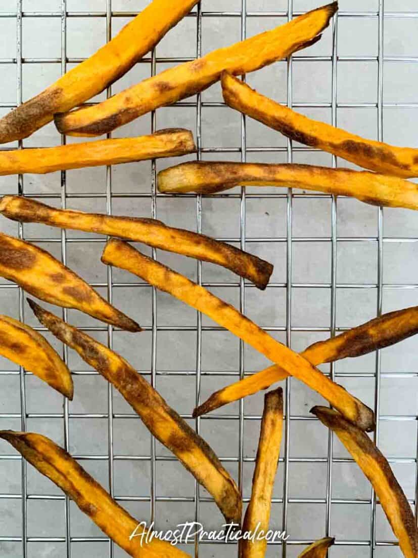 Cooked sweet potato fries on a cooling rack.