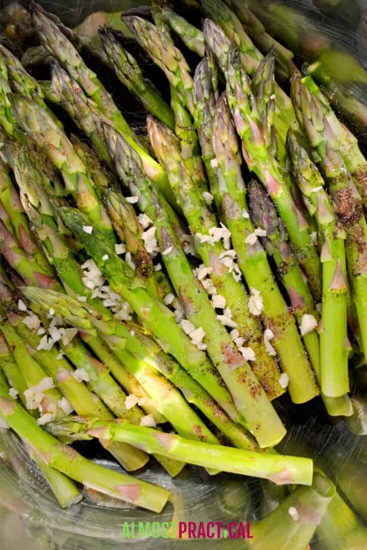 asparagus in mixing bowl topped with seasonings