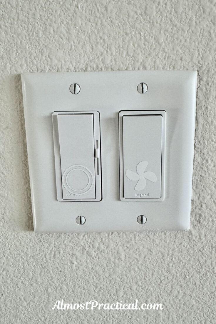 photo of rocker style light switches that have vinyl cutouts of a recess light on one and a ceiling fan on another