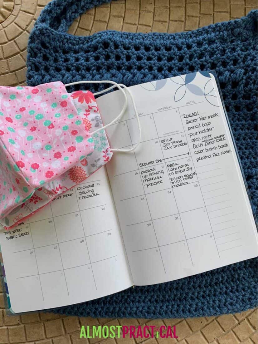 Calendar with crochet purse underneath and cloth face masks on top.