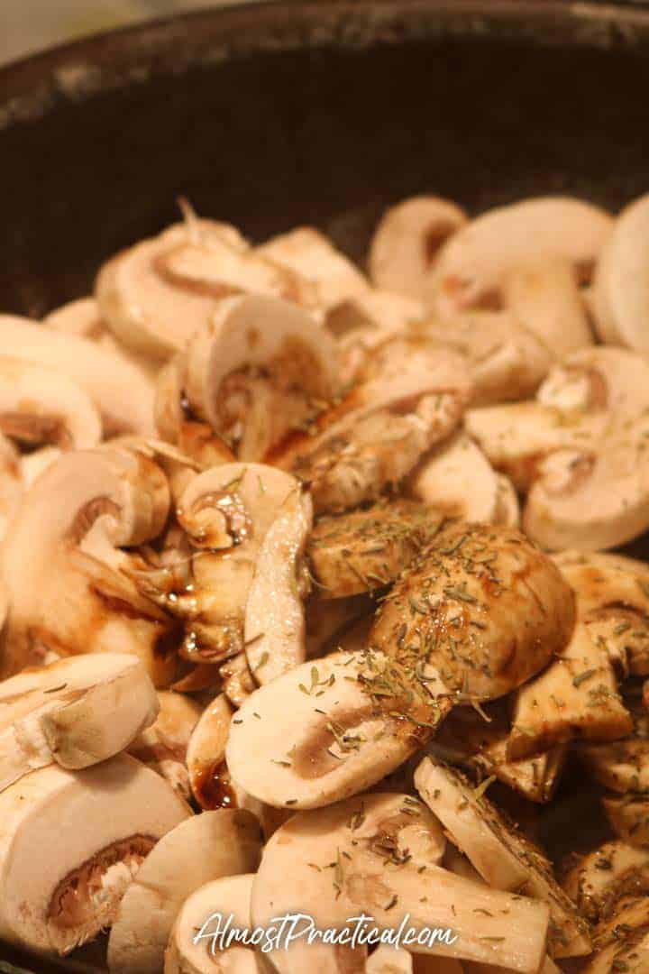 sliced mushrooms in a pan with thyme