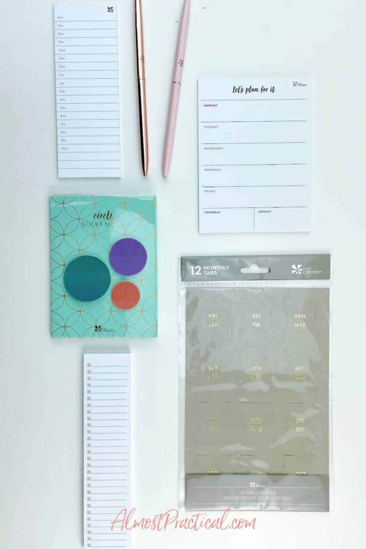 Erin Condren sticky notes, ballpoint pens, and vegan leather planner tabs.