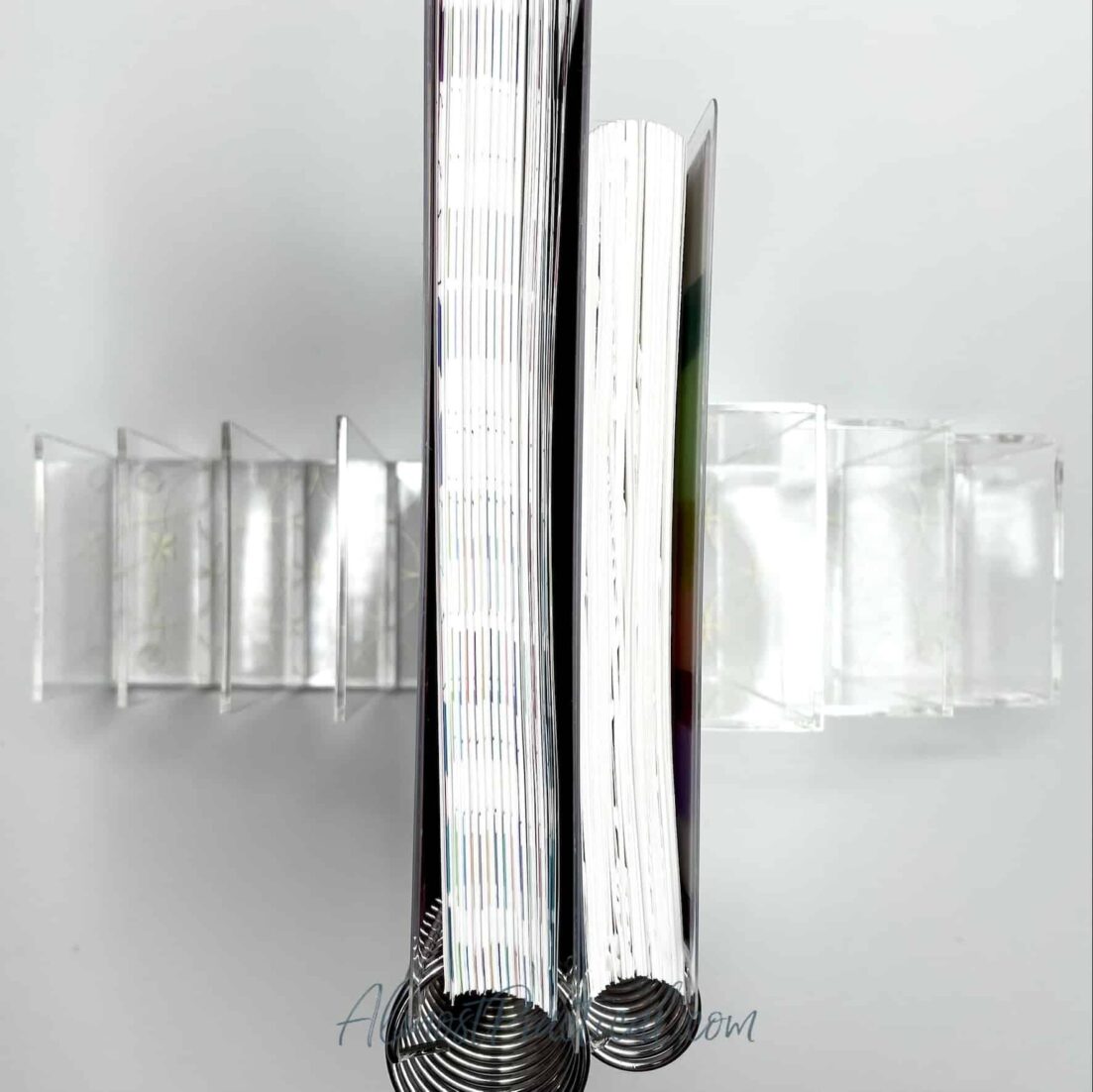 Acrylic bookends with coiled notebooks in between.