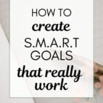 how to create smart goals that really work - words on background photo of pen and pink notebook
