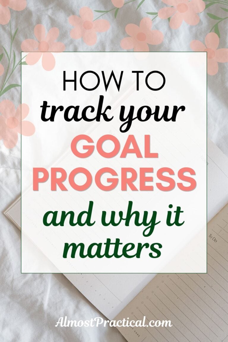 words "how to track your goal progress and why it matters" superimposed on an image of an open planner on a white fabric background