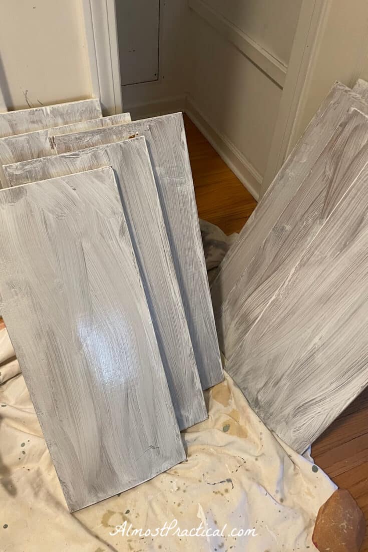 Brown linen closet shelves that are in the process of being painted white.