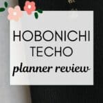 words "hobonichi techo planner review" superimposed on a photo of the actual planner which has a black cover set on a white table