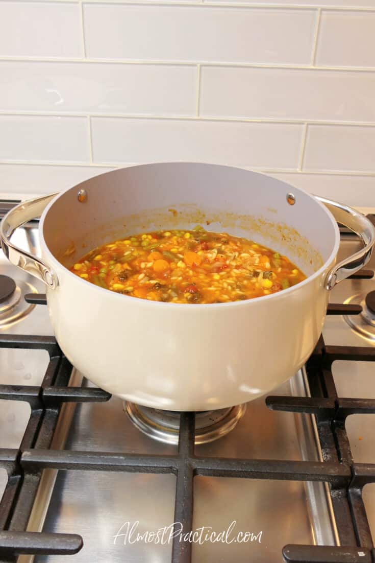 vegetable soup in cream colored dutch oven on stove
