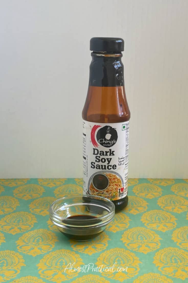 bottle of Ching's dark soy sauce next to a bowl full of soy sauce