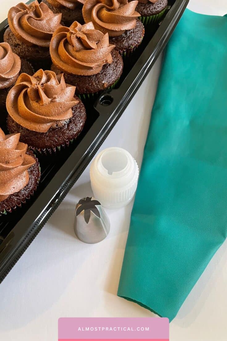 tray of chocolate cupcakes with chocolate frosting and piping tip and piping bag