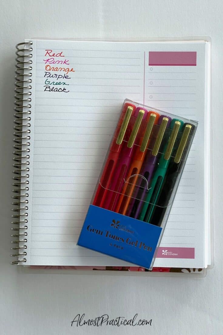 a set of jewel toned gel pens atop an open spiral bound notebook
