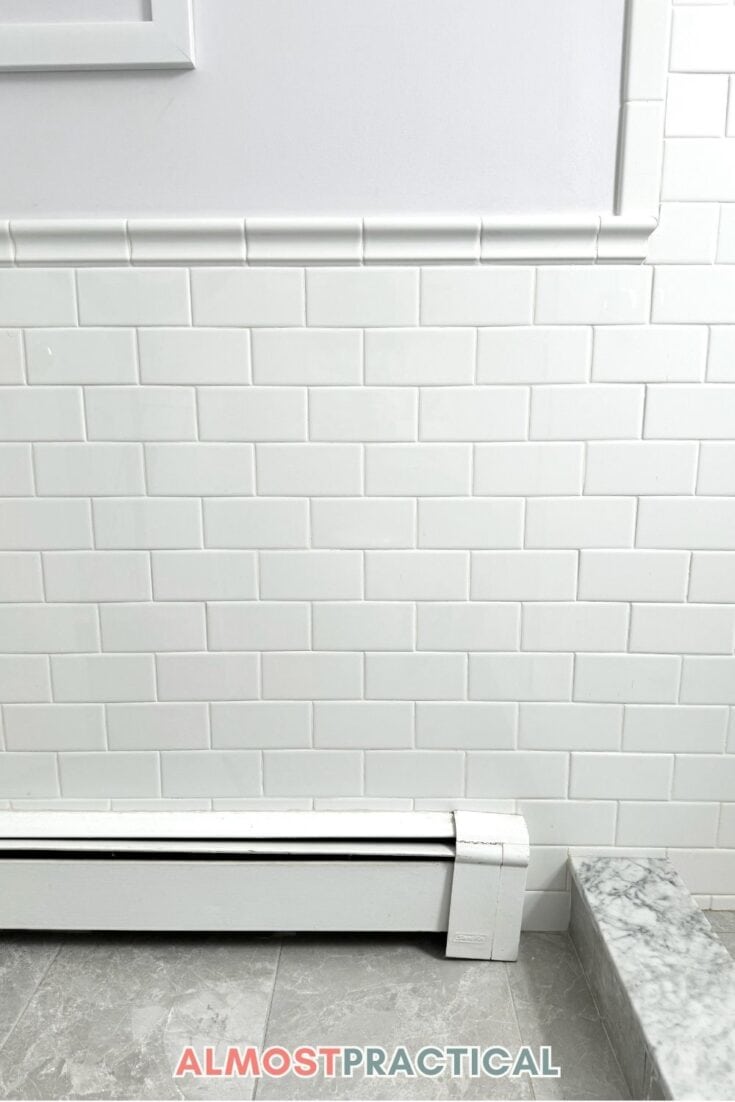 bathroom wall tiled partially with white subway tile