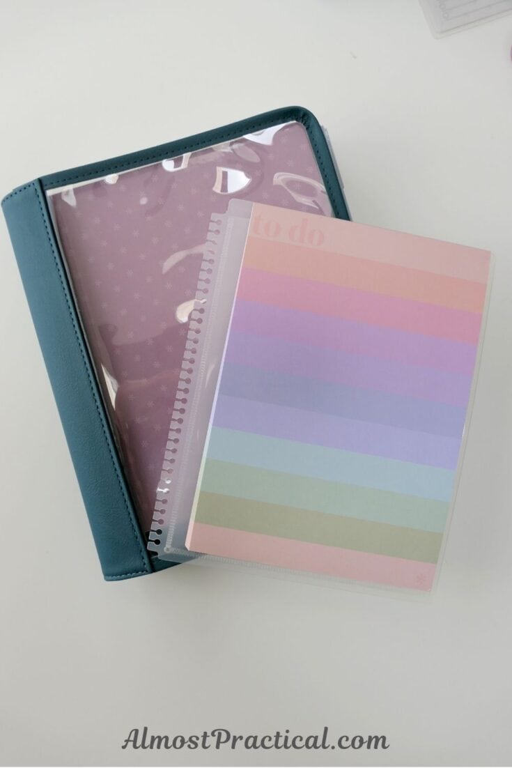 An Erin Condren Life Planner in a folio with a clear cover and a to do list notepad on top
