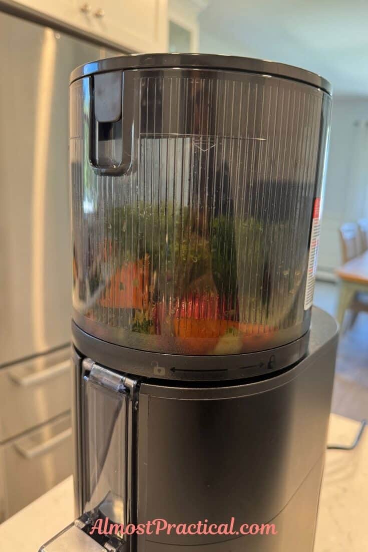 A photo of the Hurom H400 juicer in action with fruits and vegetables being churned in the hopper.