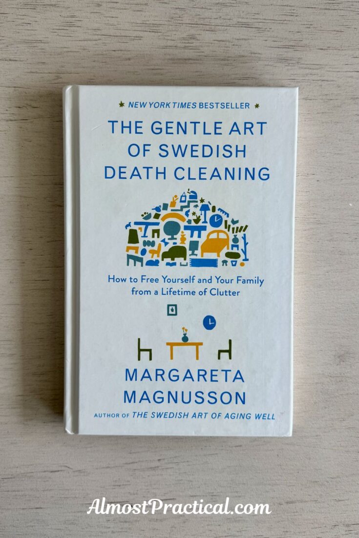 a photo of the book - the gentle art of swedish death cleaning on a gray toned wood tabletop