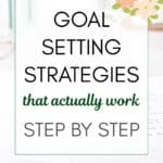 words " goal setting strategies that actually work step by step" superimposed on a photo of an open notebook on a white desk with mint green accessories in the background