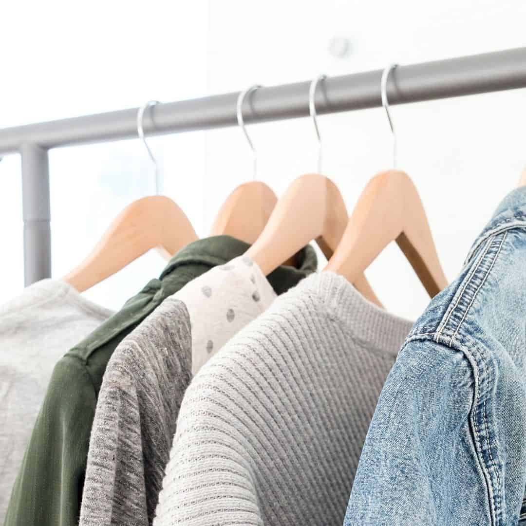 photo of clothing hanging on hangers on a rack